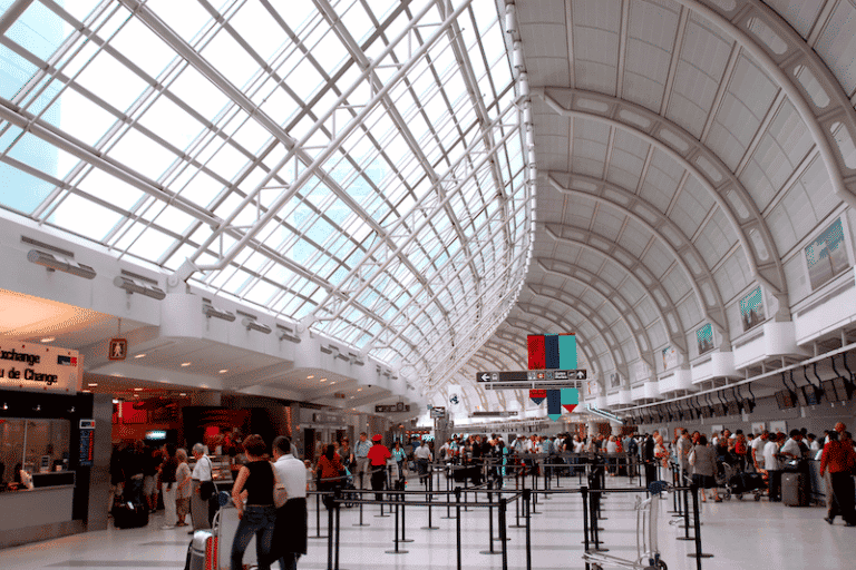 A bustling airport terminal filled with passengers and activity, emphasizing the importance of efficient and reliable airport cleaning services