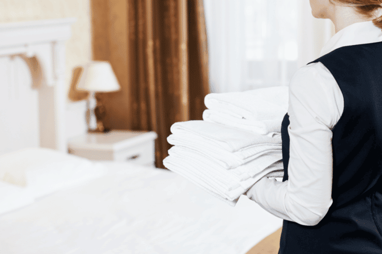 Dedicated GDI Employee Providing Excellent Hotel Cleaning Service by Delivering Fresh Towels