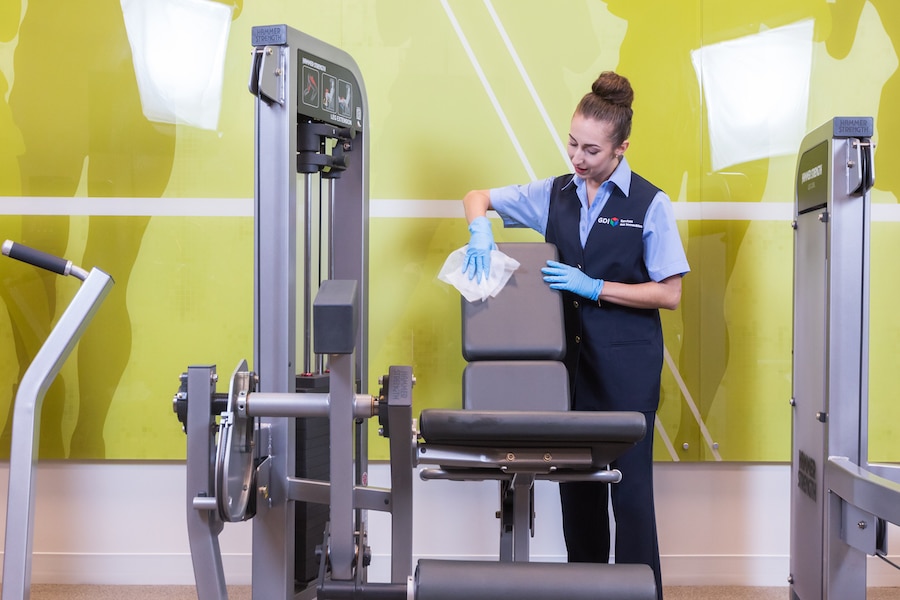 Professional Cleaning Services - Person Wiping Exercise Machine in Gym